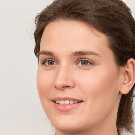 Joyful white young-adult female with medium  brown hair and grey eyes