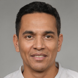 Joyful latino adult male with short  black hair and brown eyes