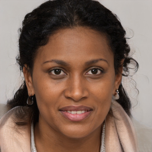Joyful black young-adult female with long  brown hair and brown eyes