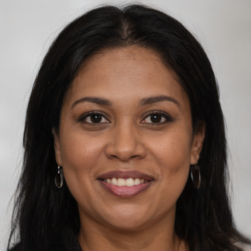 Joyful black young-adult female with long  brown hair and brown eyes