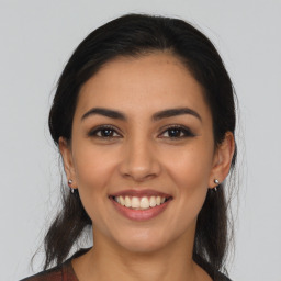 Joyful latino young-adult female with long  brown hair and brown eyes