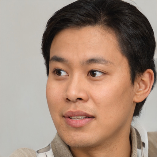 Joyful asian young-adult male with short  brown hair and brown eyes
