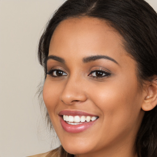 Joyful latino young-adult female with long  brown hair and brown eyes