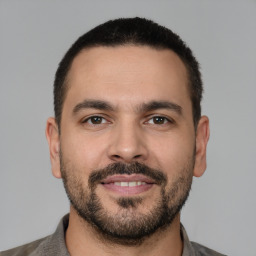 Joyful white young-adult male with short  black hair and brown eyes