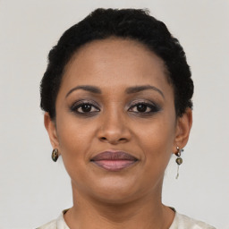 Joyful black young-adult female with short  black hair and brown eyes