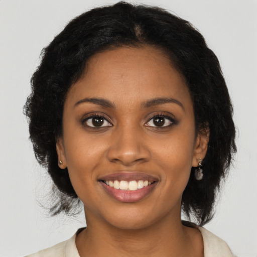 Joyful black young-adult female with long  black hair and brown eyes