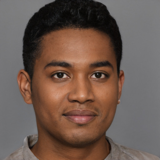 Joyful black young-adult male with short  black hair and brown eyes