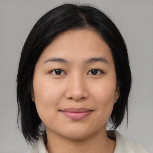Joyful asian young-adult female with medium  black hair and brown eyes