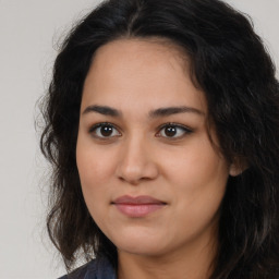 Joyful latino young-adult female with long  brown hair and brown eyes