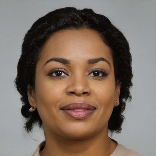Joyful black young-adult female with medium  black hair and brown eyes