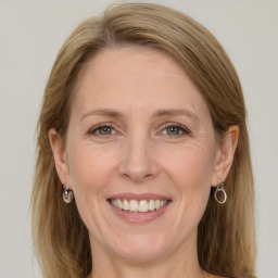 Joyful white adult female with long  brown hair and grey eyes