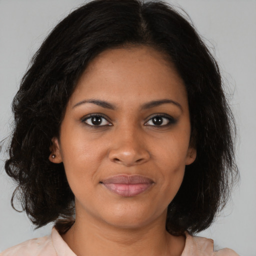 Joyful black young-adult female with medium  brown hair and brown eyes
