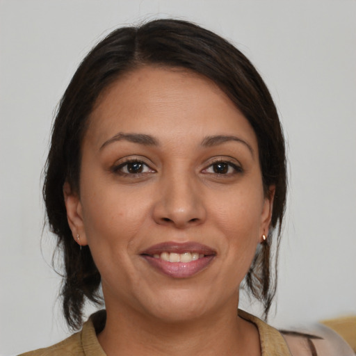 Joyful latino young-adult female with medium  brown hair and brown eyes