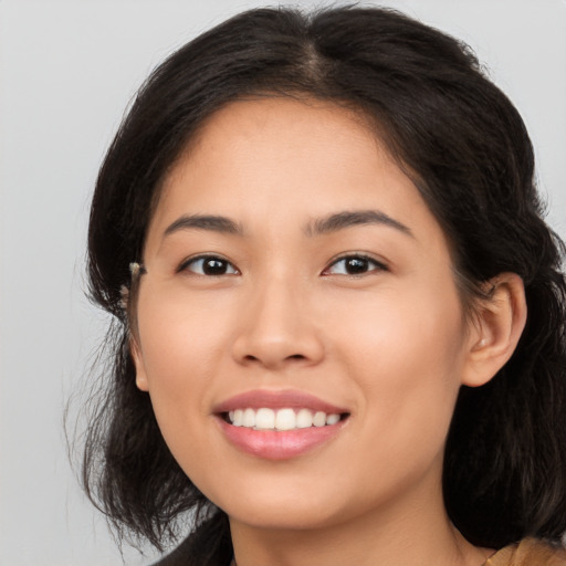 Joyful latino young-adult female with long  brown hair and brown eyes