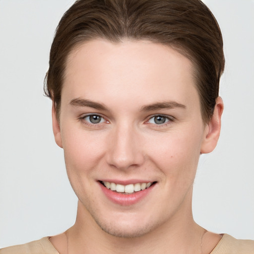 Joyful white young-adult female with short  brown hair and grey eyes