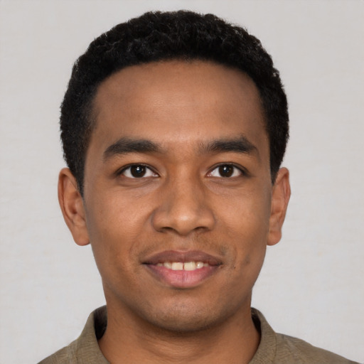 Joyful black young-adult male with short  black hair and brown eyes