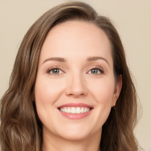 Joyful white young-adult female with long  brown hair and green eyes