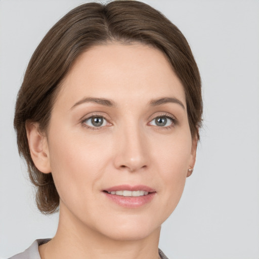 Joyful white young-adult female with medium  brown hair and grey eyes