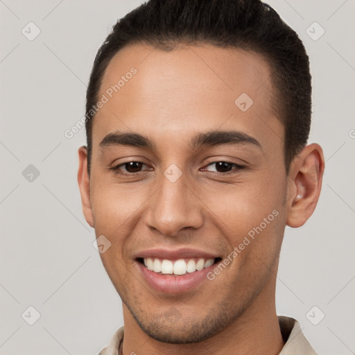 Joyful white young-adult male with short  brown hair and brown eyes