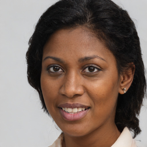 Joyful black young-adult female with medium  brown hair and brown eyes