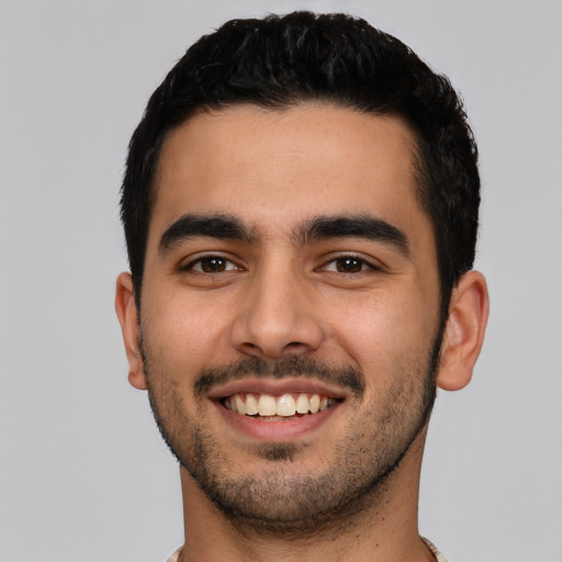 Joyful latino young-adult male with short  black hair and brown eyes