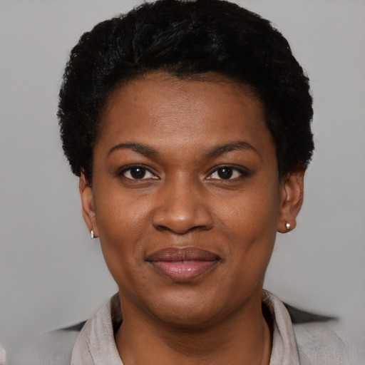 Joyful black young-adult female with short  black hair and brown eyes