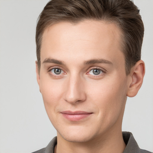 Joyful white young-adult male with short  brown hair and grey eyes