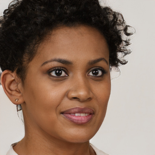 Joyful black young-adult female with short  brown hair and brown eyes
