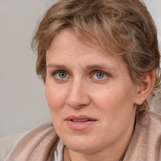 Joyful white adult female with medium  brown hair and blue eyes