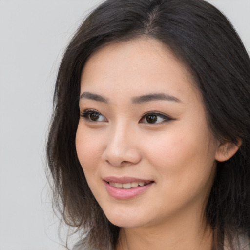 Joyful asian young-adult female with long  brown hair and brown eyes
