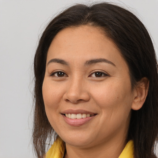 Joyful asian adult female with long  brown hair and brown eyes