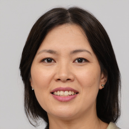 Joyful asian young-adult female with medium  brown hair and brown eyes