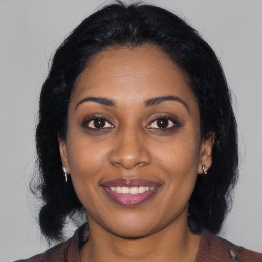 Joyful black young-adult female with long  black hair and brown eyes