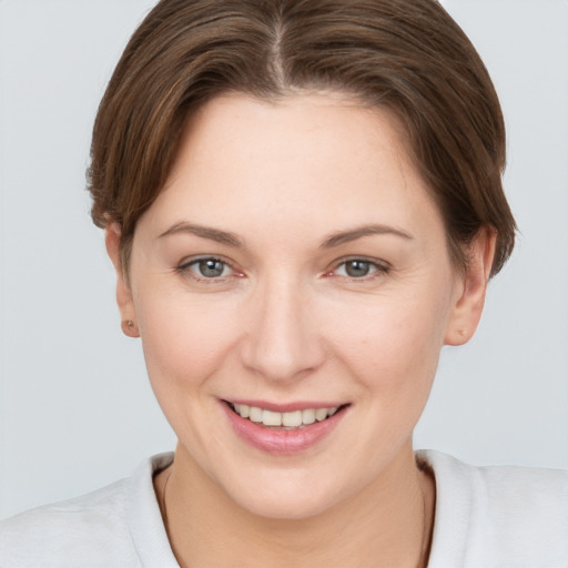 Joyful white young-adult female with short  brown hair and grey eyes