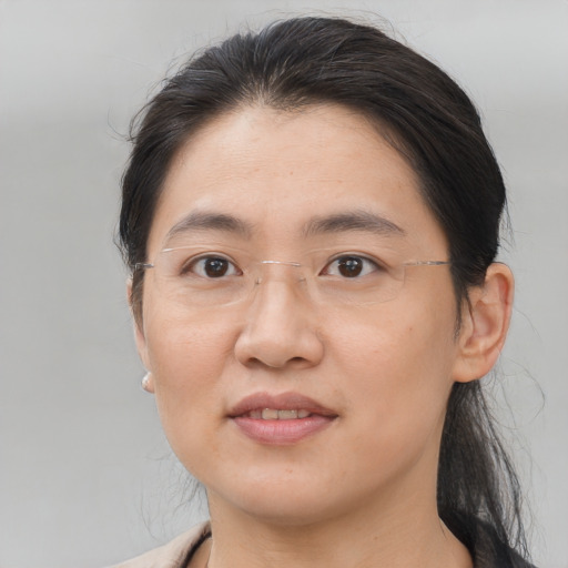 Joyful asian young-adult female with medium  brown hair and brown eyes