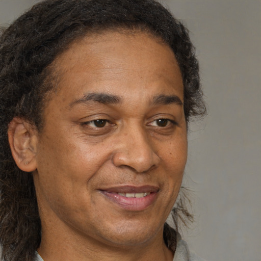 Joyful black adult male with short  brown hair and brown eyes