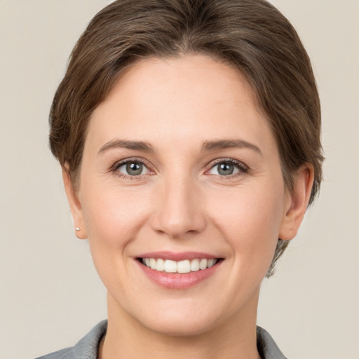 Joyful white young-adult female with short  brown hair and grey eyes