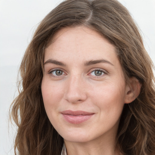 Joyful white young-adult female with long  brown hair and grey eyes