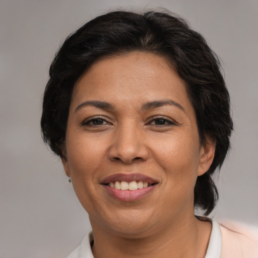 Joyful latino adult female with medium  brown hair and brown eyes