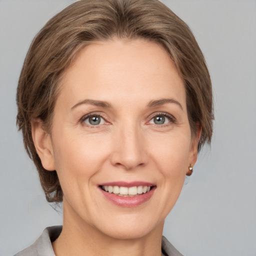 Joyful white adult female with medium  brown hair and grey eyes