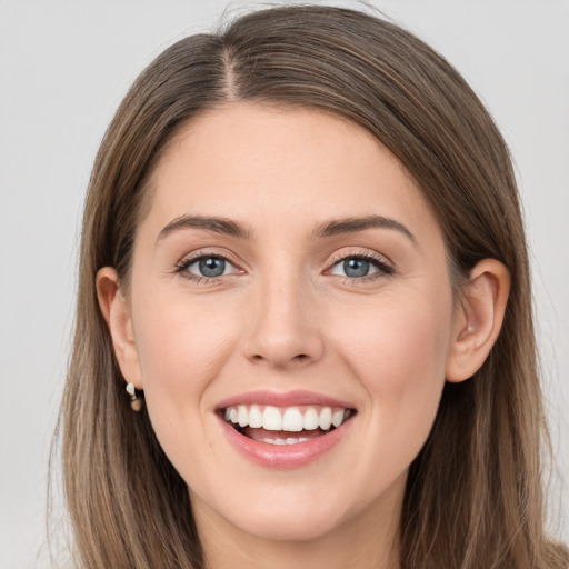 Joyful white young-adult female with long  brown hair and grey eyes