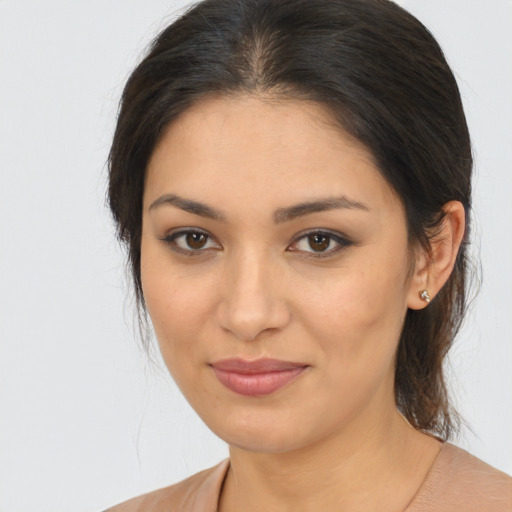 Joyful latino young-adult female with medium  brown hair and brown eyes