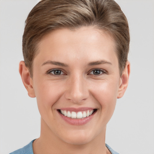 Joyful white young-adult female with short  brown hair and grey eyes