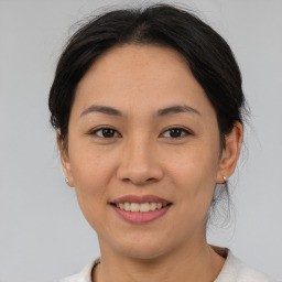 Joyful asian young-adult female with medium  brown hair and brown eyes