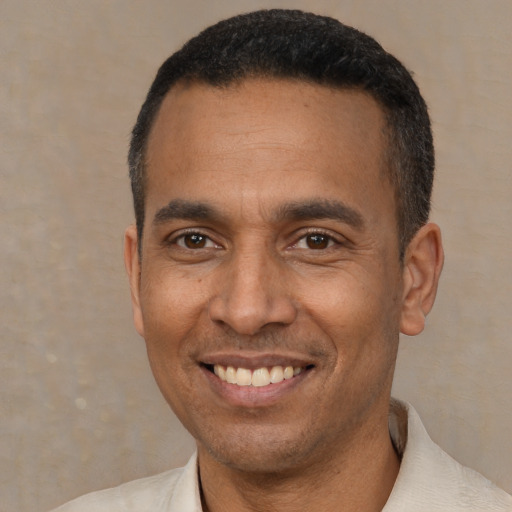 Joyful latino adult male with short  black hair and brown eyes