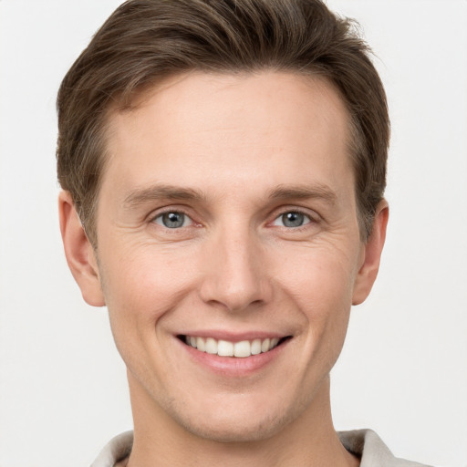 Joyful white young-adult male with short  brown hair and grey eyes