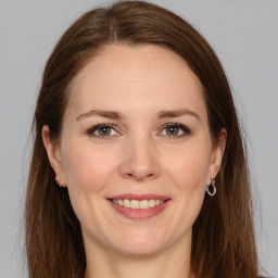 Joyful white young-adult female with long  brown hair and grey eyes