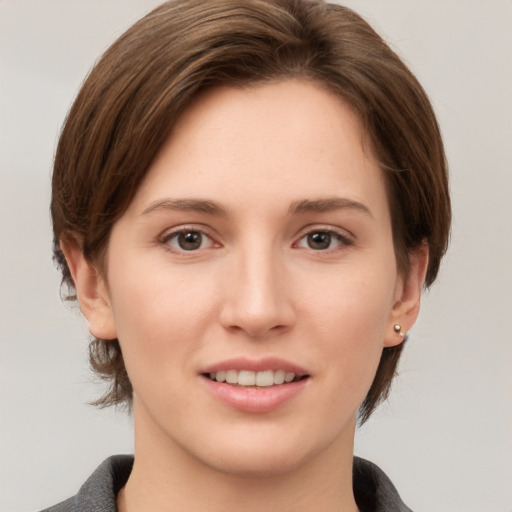 Joyful white young-adult female with medium  brown hair and grey eyes