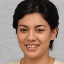 Joyful latino young-adult female with medium  brown hair and brown eyes