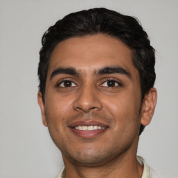 Joyful latino young-adult male with short  black hair and brown eyes